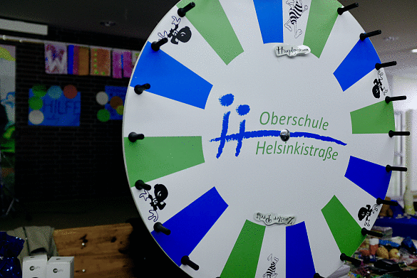 Bild eines Losrades mit dem Logo der Oberschule an der Helsinkistraße